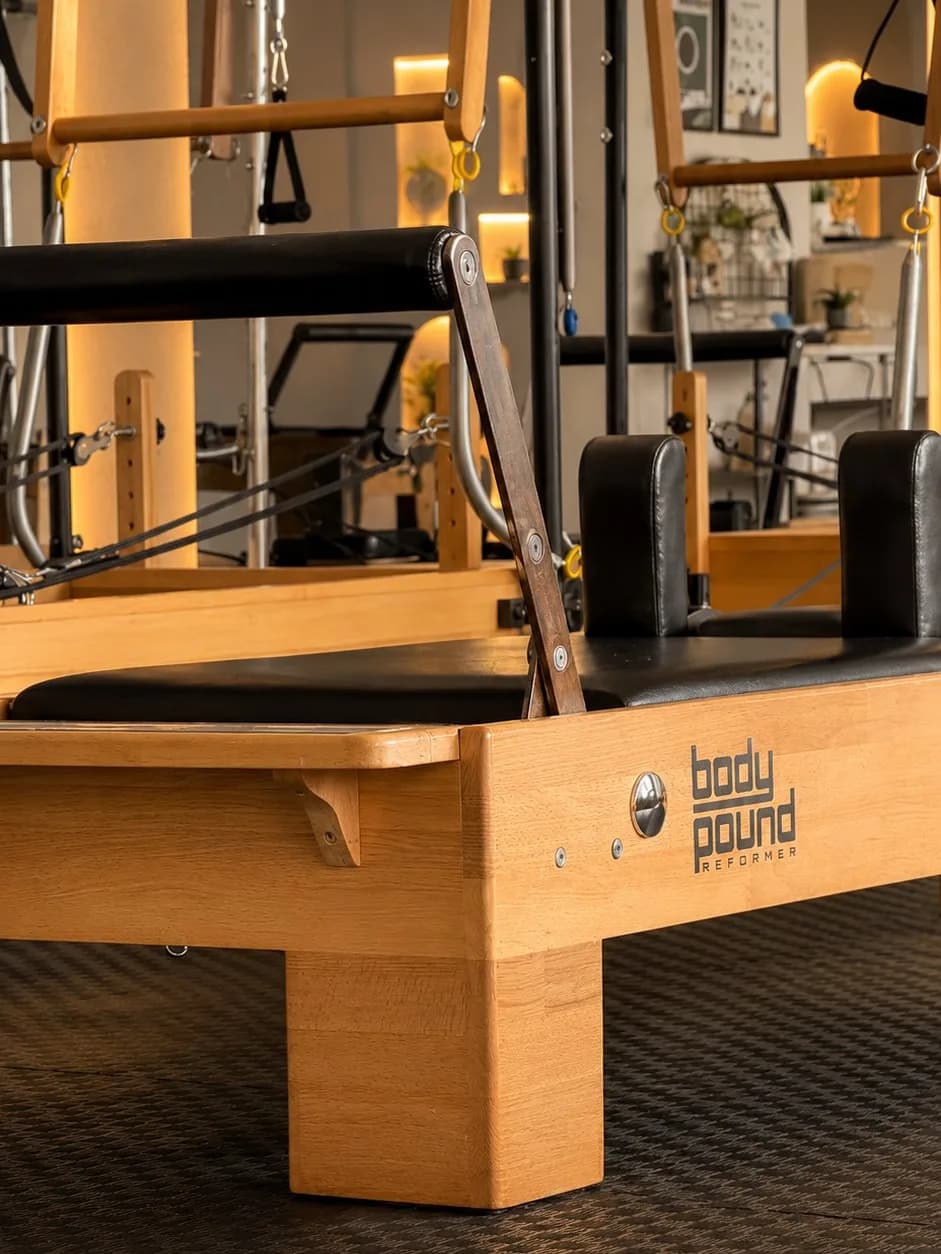 Body Pound reformer detayı — ahşap çerçeve ve marka logosu yakın çekim